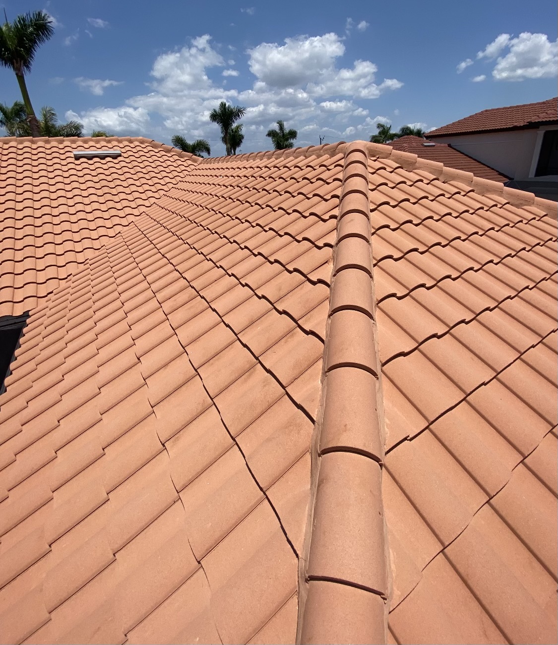 a roof recently cleaned from the company Clean Roof, blue sky with clouds a roof recently cleaned from the company Clean Roof, blue sky with clouds