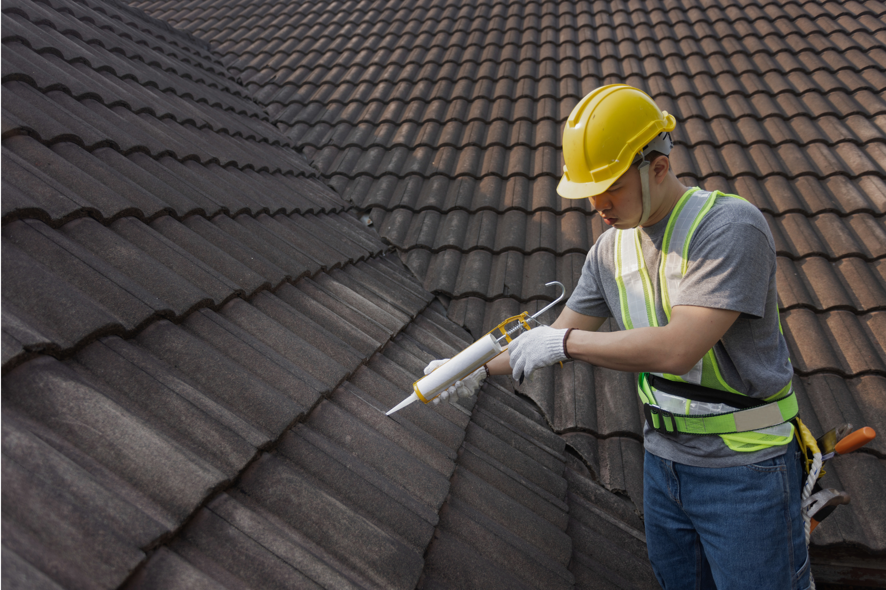 man fixing roof tiles