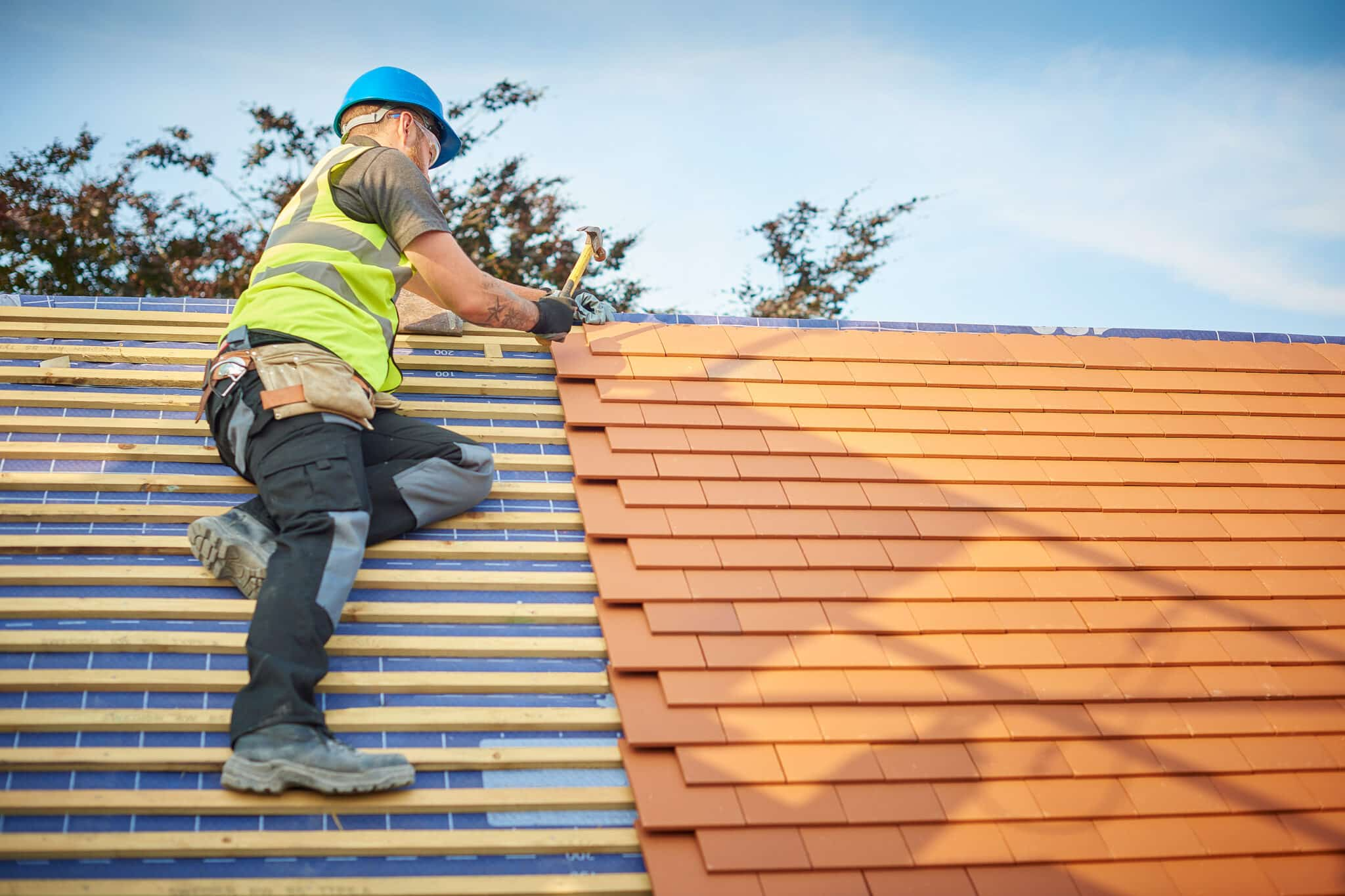 worker on shingle roof