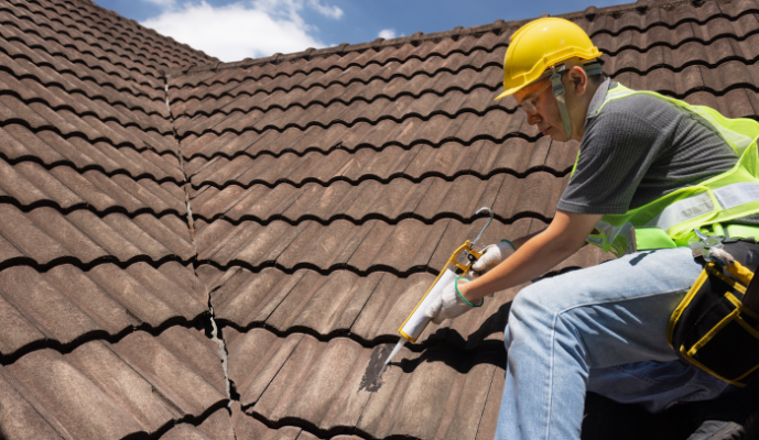 Worker applying roof sealant